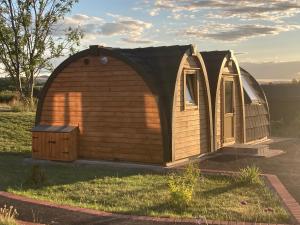 LeightonHedgehog Glamping Pod School House Farm的一个小木房子,设有门和窗户