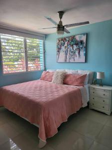Toa BajaRelaxing Property with Stunning Views and Pool的卧室配有粉红色的床和吊扇
