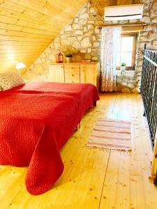 SzentantalfaZsóka Fogadója的一间卧室设有红色的床和石墙