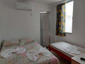 萨尔瓦多Casarão Nazaré Hostel的一间卧室设有一张床和一个窗口