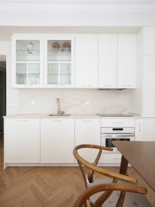 马德里DELUXE APARTMENT NEAR GRAN VIA的厨房配有白色橱柜和木桌
