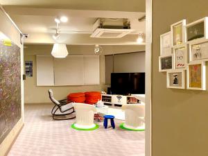 釜山韩国宿旅舍的客厅配有白色椅子和电视