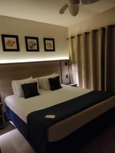 博西坎加Summit Beach Hotel Boiçucanga的一间卧室配有一张大床,提供黑白枕头
