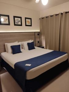 博西坎加Summit Beach Hotel Boiçucanga的一间卧室配有一张带蓝色枕头的大床