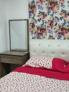 莎阿南Vista Royal Homestay的一间卧室配有一张带镜子和床罩的床