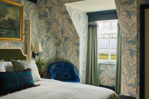 特伦Marine Troon的卧室设有蓝色椅子,靠窗