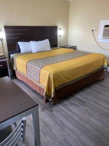 萨凡纳萨凡纳汽车旅馆 的酒店客房配有一张床铺和一张桌子。
