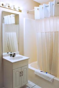 约克Victorian Inn & Suites-York的白色的浴室设有水槽和淋浴。