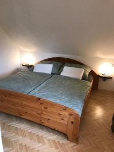 PeratschitzenKlopeinerperle的一间卧室配有一张木床和两把白色椅子
