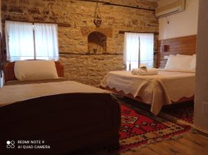 吉诺卡斯特Guest House Salaria的一间卧室设有两张床和石墙