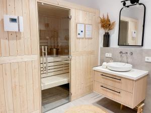 沙博伊茨My Baltic Sea - Ferienwohnungen im Seaside House的浴室配有盥洗盆和带镜子的淋浴
