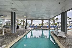 默特尔比奇Harbourgate Resort Waterfront Condo with Pool!的大楼内带蓝色椅子的游泳池