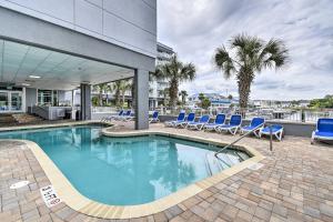 默特尔比奇Harbourgate Resort Waterfront Condo with Pool!的一座带蓝色椅子的游泳池和一座建筑
