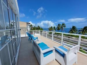 圣安德烈斯Bahia San Andres Hospedaje的阳台配有2把蓝白椅子和海洋
