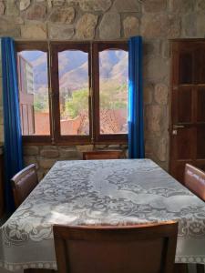 蒂尔卡拉Hospedaje Fortaleza Indigena的一间带桌子和大窗户的用餐室