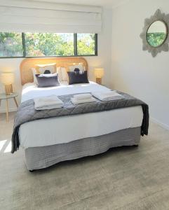 努萨维尔Noosa River Retreat Apartments - Perfect for Couples & Business Travel的白色客房内的一张大床,配有镜子