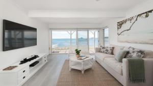 萨拉曼德湾The Beach Shack on Wanda - Brand New Beachfront Luxury的带沙发和电视的白色客厅