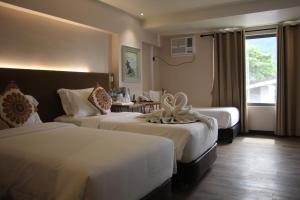 爱妮岛库纳酒店 的酒店客房设有两张床和窗户。