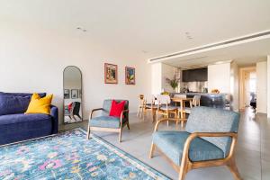 墨尔本Luxury beachside apartment的客厅配有沙发、椅子和桌子