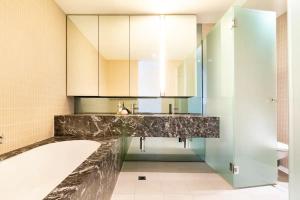 墨尔本Luxury beachside apartment的浴室配有盥洗盆和浴缸。