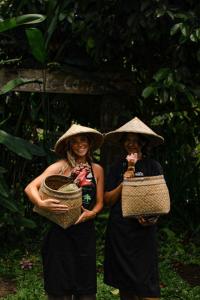 塔巴南Bali Jungle Camping by Amerta Experience的两个戴帽子的女人站在彼此旁边