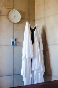 HekpoortAvela Lodge的挂在墙上的时钟和三件白色衬衫