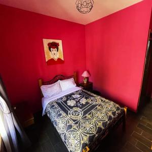 瓜纳华托Casa Jardín的一间卧室配有一张红色墙壁的床