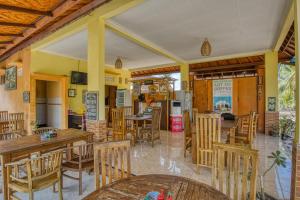 珀尼达岛Misa Guest House的一间带木桌椅的餐厅和一间厨房