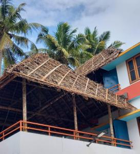 瓦尔卡拉Madhav Mansion Beach Resort的一座棕榈树顶部的建筑