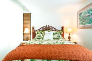 希洛Waiakea Villas 2-207的一间卧室配有一张带枕头的床