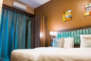 恩德培Hotel Horizon Entebbe的酒店客房,设有两张床和蓝色窗帘