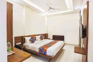 印多尔FabHotel Balaji Paradise的一间卧室配有一张床和一台电视