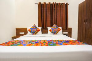 印多尔FabHotel Balaji Paradise的一间卧室,床上有五颜六色的被子
