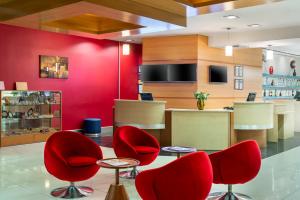 加济安泰普加济安泰普宜必思酒店的一间设有红色椅子和红色墙壁的等候室