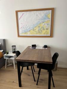 奥斯坦德Cosy Studio Testerep , Newly Renovated的一张带椅子的木桌和墙上的绘画