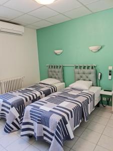 卡里勒鲁埃加里酒店的蓝色墙壁客房的两张床