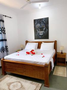 帕杰Tamu House Pajé Beach的一间卧室,床上有红色的鲜花