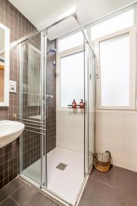 格拉纳达Apartamento Ronda Genil con parking gratuito的一个带水槽的玻璃淋浴间