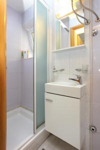 特罗吉尔Apartments by the sea Trogir - 19575的浴室配有白色水槽和淋浴。