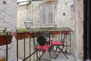 特罗吉尔Apartments by the sea Trogir - 19575的阳台上摆放着一双红色椅子