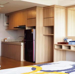 KlapaduaU Residence Tower2 Supermal by Lippo Karawaci的厨房配有黑色冰箱和木制橱柜。