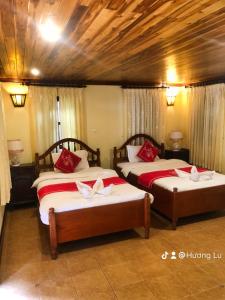 琅勃拉邦帕莎纳精品酒店的一间卧室配有两张红色和白色床单