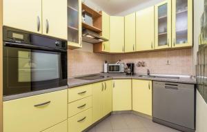 奥帕提亚Vallelosca Garden的厨房配有黄色橱柜和黑色用具