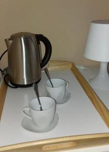 科巴里德Mike's Rooms的茶壶和桌子上的两个杯子