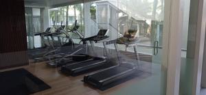 普吉镇A2 Pool Resort - SHA Plus的健身房设有数台跑步机和玻璃墙