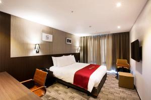 济州市华美达济州市酒店 的配有一张床和一张书桌的酒店客房