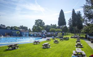 北安普敦Lakes and woodlands Overstone Holiday Park的一个带野餐桌的草地游泳池