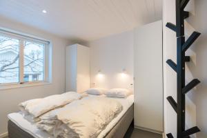 布鲁克斯瓦拉那Bruksvallarna - Modern fjällstuga med panoramautsikt och WiFi的一间卧室配有一张带白色床单的床和一扇窗户。