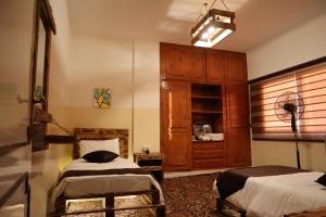 瓦迪穆萨Petra Wooden House的一间卧室配有两张床和梳妆台。
