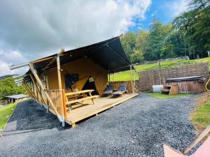 多尔盖罗Quirky Safari Tent with Hot Tub in Heart of Snowdonia的砂石路上带黑色屋顶的帐篷